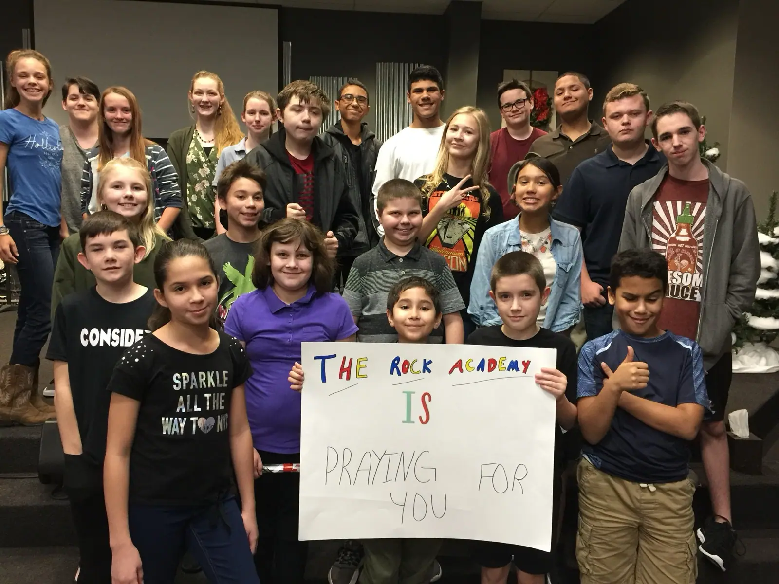 Rock Academy students together holding a handmade sign