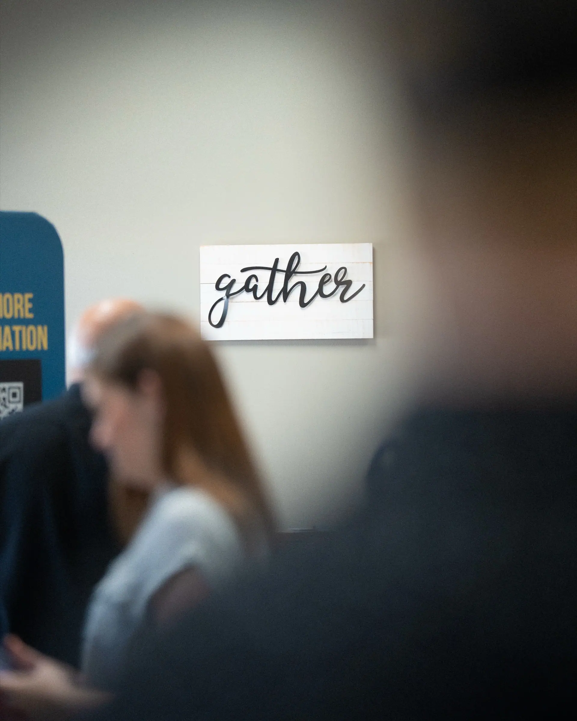 People gathering under a sign that reads gather