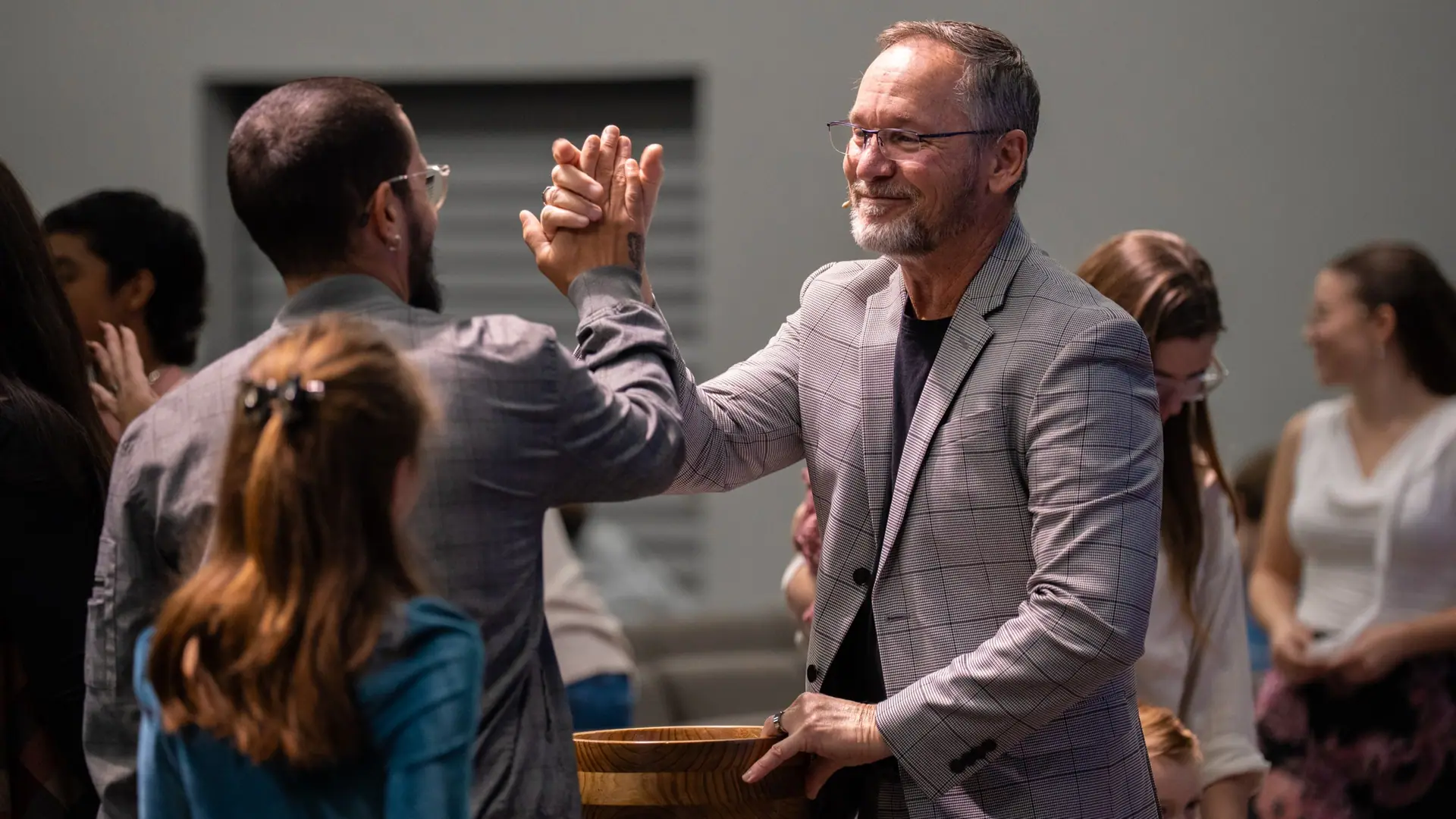 Pastor Steve Parker high-fiving a dad and his daughter on Sunday