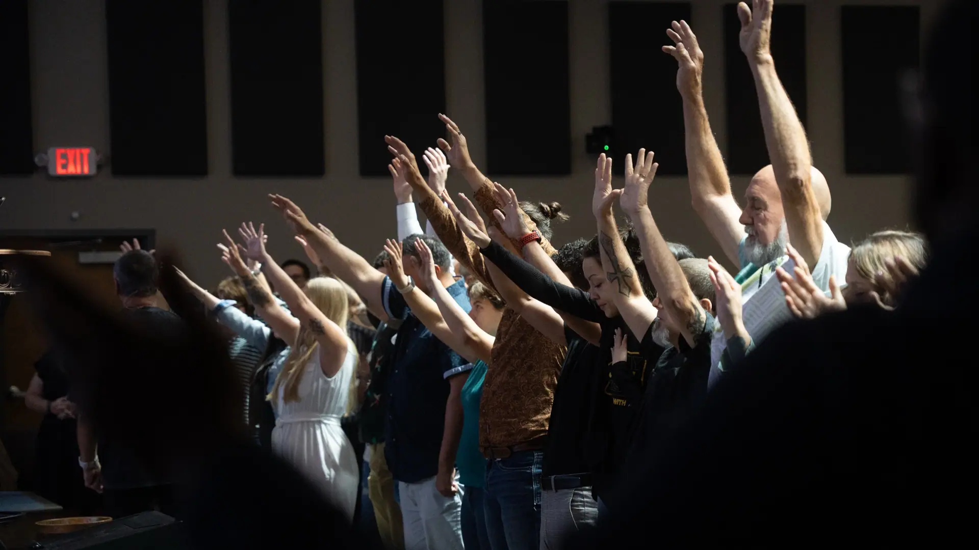 The Rock congregation worshiping with hands raised