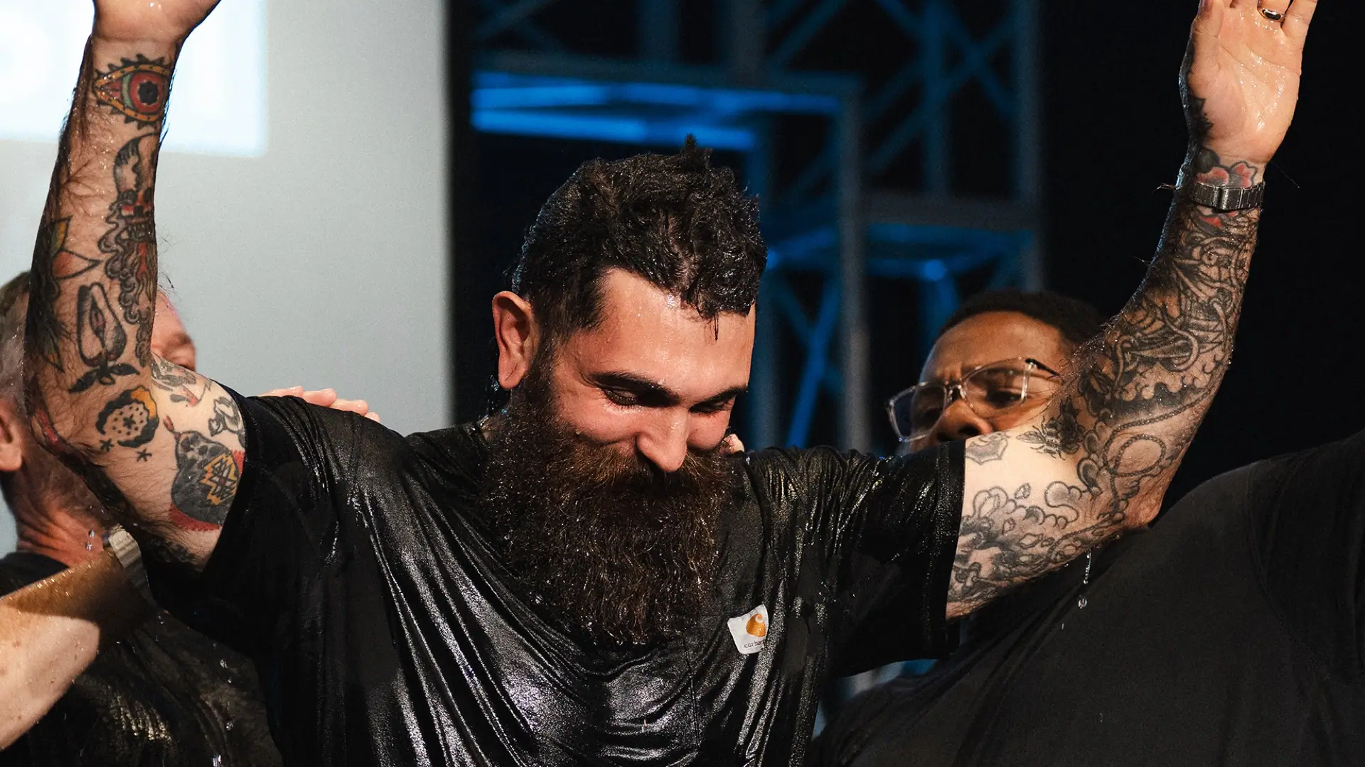 A man celebrating as he comes up from water baptism