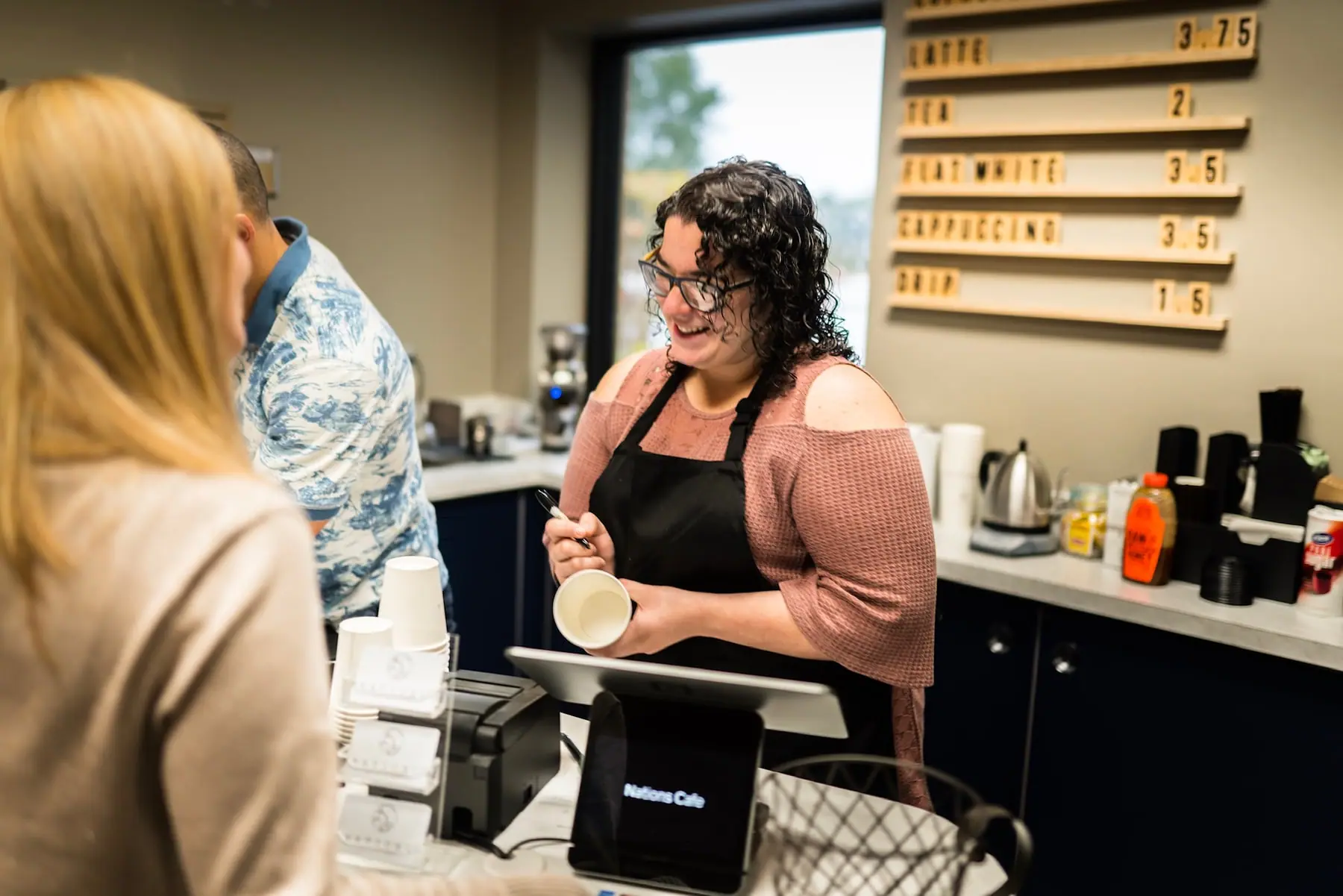 A barista serving coffee at Nations Cafe